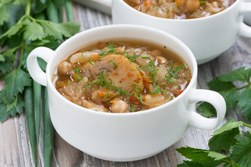 soup with cabbage, mushrooms and chickpeas on wooden table