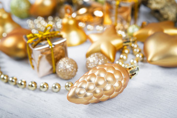 Brilliant gold baubles and cones like christmas decoration. Yellow balls ribbon, gift, bow and tinsel isolated on white background.