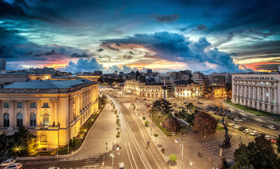 Long exposure shot of the Revolution Square near Victoria Avenue in Bucharest, Romania. Traffic and historical buildings.Bucuresti - obrazy, fototapety, plakaty