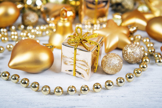Brilliant gold baubles and cones like christmas decoration. Yellow balls ribbon, gift, bow and tinsel isolated on white background.