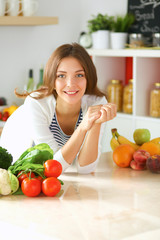 Young woman standing near desk in the kitchen