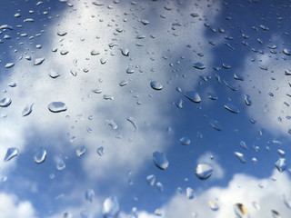rain drops on windowpane against clouds