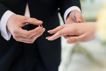 Obraz na płótnie Canvas wedding rings and groom bride