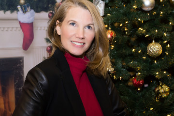 Blonde Female Posing with Christmas Tree Looking Up Smiling