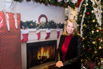 Blonde Female Sitting by Fireplace and Christmas Tree