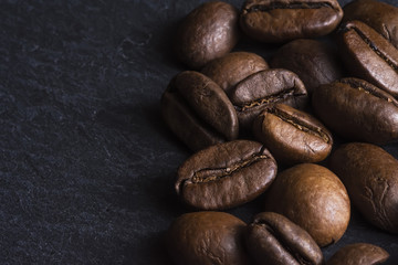 Coffee Beans Background Close Up. Roasted Coffee Beans on Dark Stone Surface.