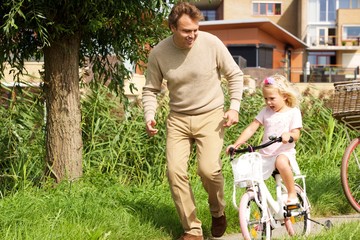 Fototapeta premium Father teaching her daughter cycling