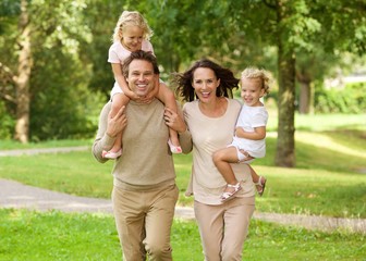 Fototapeta premium Happy beautiful family of four running in park