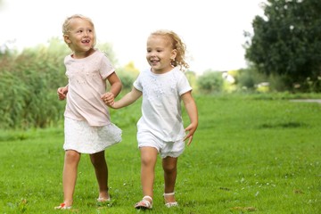 Two little girls walking in the park