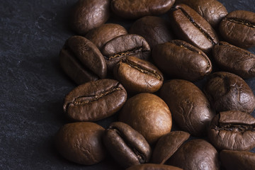 Coffee Beans Background Close Up. Roasted Coffee Beans on Dark Stone Surface.