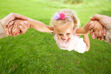 Little girl being spun in circles at park