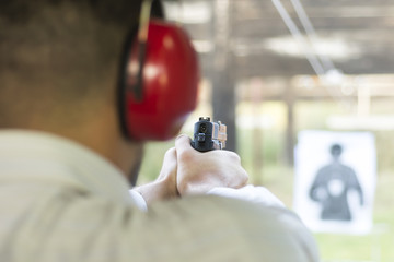 Shooting with Gun at Target in Shooting Range. Man Practicing Fire Pistol Shooting. - 124133527