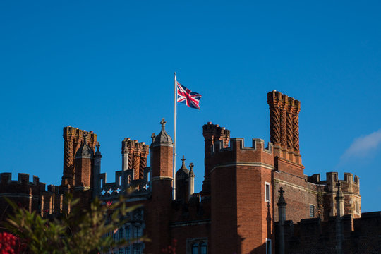 Union Jack flying over palace entrance in sunshine against