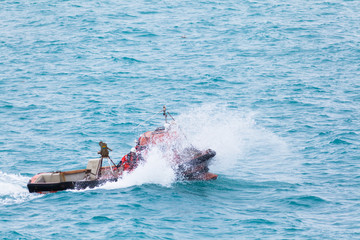 Motor boat lifts splashes jumping on a wave