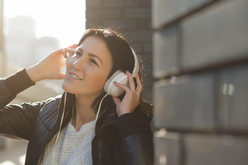 Woman with white earphones listen music in city