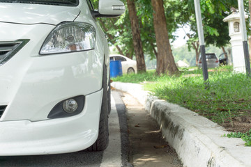 Close up front of new silver car parking on the asphalt road.