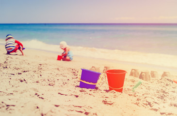 Fototapeta na wymiar kids play with sand on beach
