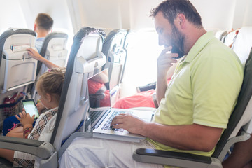 Businessman with laptop in airplane