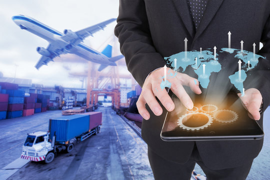 Image of businessman holding tablet ,Growing business concept on Global network coverage world map , Logistic Import Export background (Elements of this image furnished by NASA)