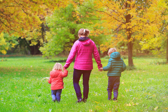 mother with two kids walking in autumn fall