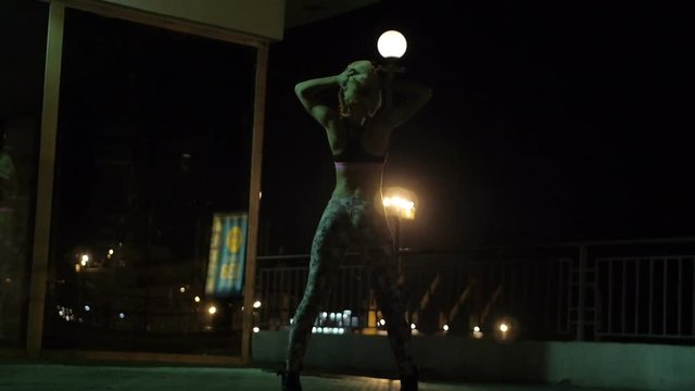 Girls dancing twerk in a public place in a mirror on the night street