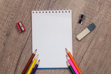 blank paper and colorful pencils on wooden table