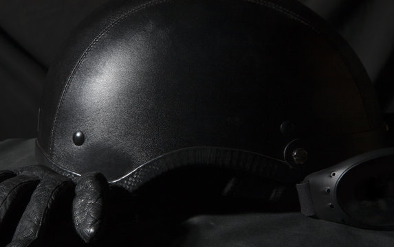 black motorcycle helmet with goggles on black background