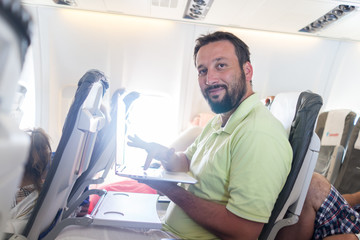 Businessman with laptop in airplane