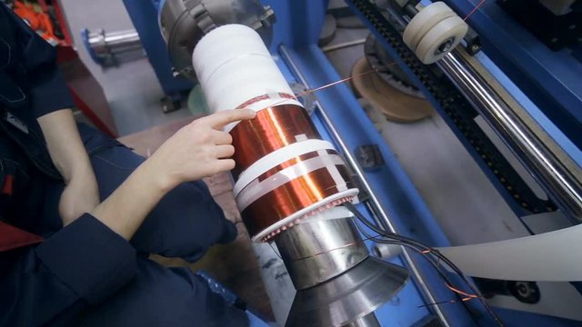 Transformer, engine production. Worker operates with electric cooper wires, winding of the transformer. HD.