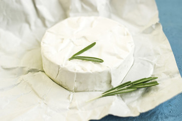 Sliced round camembert cheese traditional milk creamy dairy product with rosemary
