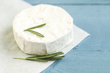 Sliced round camembert cheese traditional milk creamy dairy product with rosemary