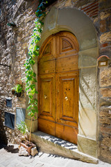 Fototapeta na wymiar Entrance - front wooden retro door in typical small Tuscany town