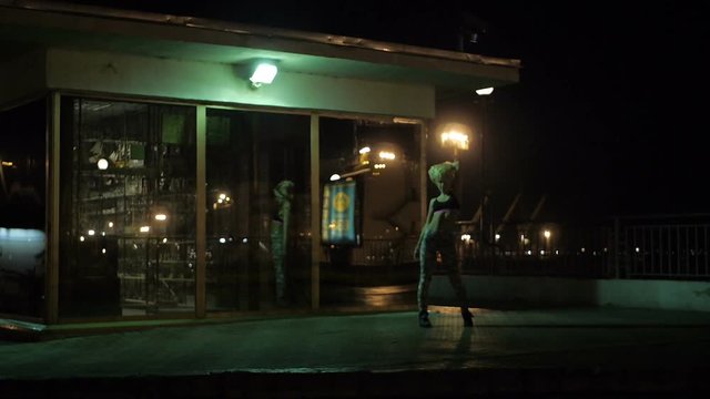Girls dancing twerk in a public place in a mirror on the night street