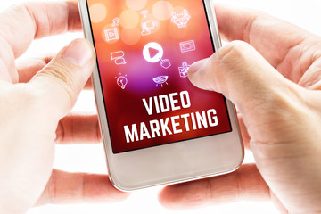 Close up Two hand holding mobile phone with Video marketing word
