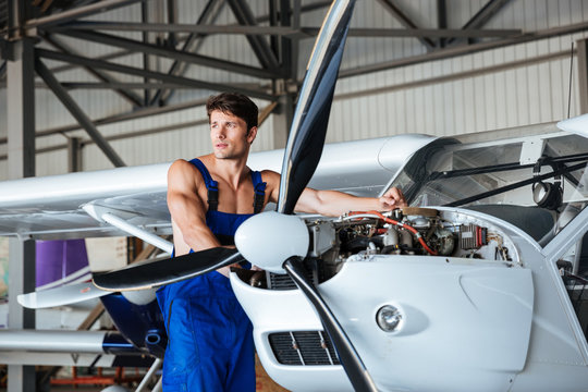 Handsome young repair man fixing plane engine