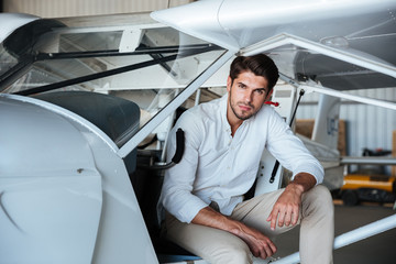 Man pilot sitting in small airplane