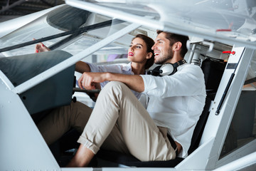 Couple sitting and talking in cabine of small aircraft