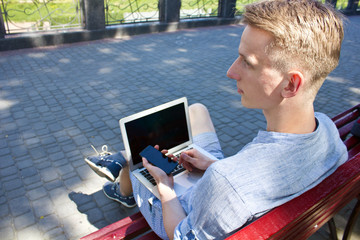 Young man with laptop looking aside