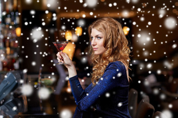 glamorous woman with cocktail at night club or bar