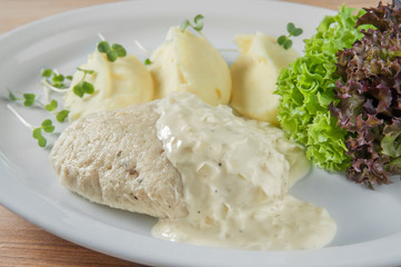 dish meal with mashed potatoes, fish cutlet poured sauce