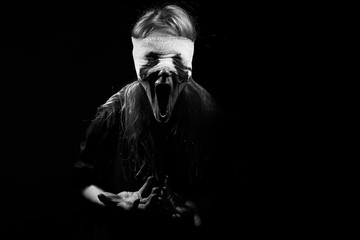 scared bloody girl screaming on black background with copyspace, monochrome
