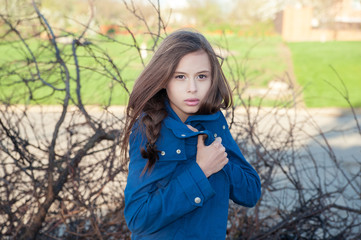 girl wrapped up in a blue sweater in the wind with tousled hair