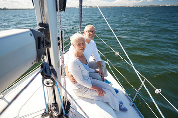 senior couple hugging on sail boat or yacht in sea