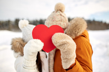 happy couple with red heart over winter landscape