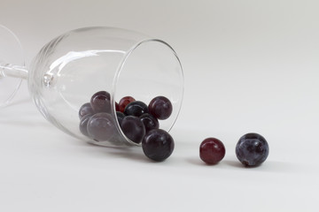 grape in wine glass on table