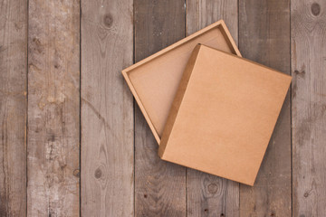 Opened cardboard box on wooden background