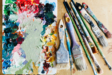 Obraz premium Brushes with palette in the creative background. Colorful element.