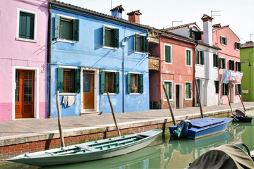 Fototapeta na wymiar traditional colored houses by a canal of Burano island in the venetian lagoon, Venice, Italy