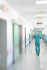 Doctors and nurses walking in hospital hallway, blurred motion.