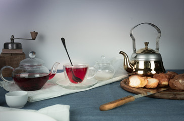 still life. coffee mill, hibiscus tea, buns on a blue tablecloth